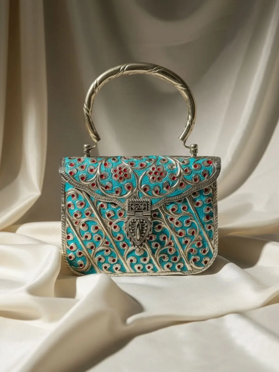 Turquoise engraved VARNA clutch arranged on ivory silk